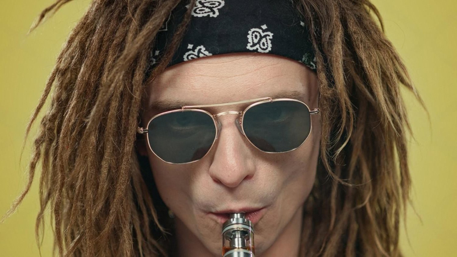 Close-up of a person inhaling from a disposable vape pen